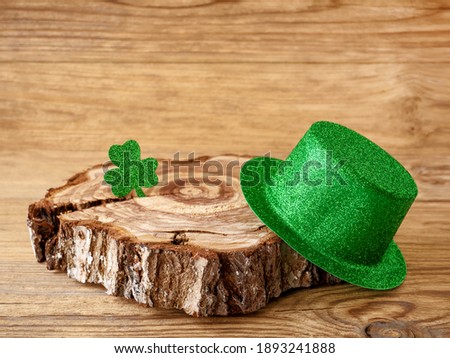 Shamrock clover and green hat on a wooden table, symbol of the Irish holiday of St Patrick's Day.