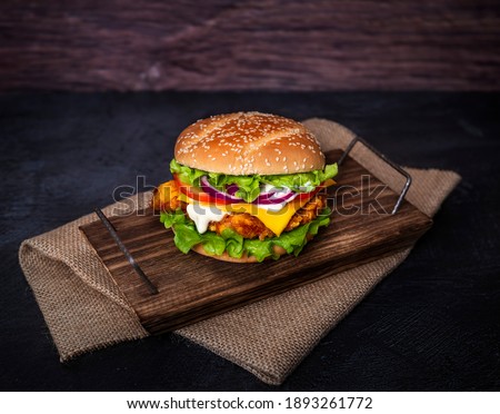Crispy chicken burger on a wooden plate