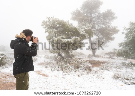 Photographer taking pictures of the trees covered with snow. Winter concept. Forest full of snow.


