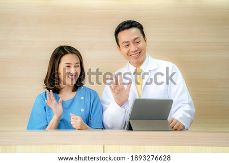 Conference call and consult Video online. doctor and nurse speaking to tablet device at the lobby desk. Healthcare and medicine therapy in concept suggestion by online internet digital technology.