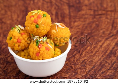 Group Of Indian Mithai Jodhpuri Ladoo Laddu Also Called Boondi Or Bundi Ladoo Decorated In White Bowl. Meetha Laddoo Deep Fried In Shuddha Desi Ghee On Wooden Brown Background With Copy Space For Text Royalty-Free Stock Photo #1893310492