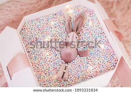Gift box with pink rabbit. Greeting card Festive holiday pastel backdrop. Birthday congratulations. Happy valentines day, mothers day, international womens day 8 march, Christmas New Year present