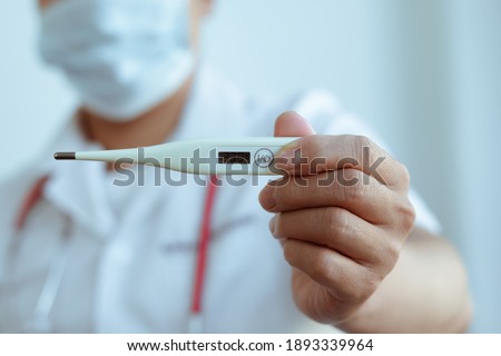 Medical thermometer in palm, hand of a doctor or nurse. Royalty-Free Stock Photo #1893339964