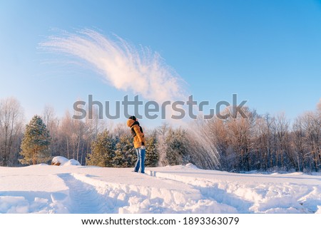 The young man, with a sharp wave of his hand, pours hot water from a cup. The paradoxical "Mpemba effect". Effect of the blast of frosty smoke signal.