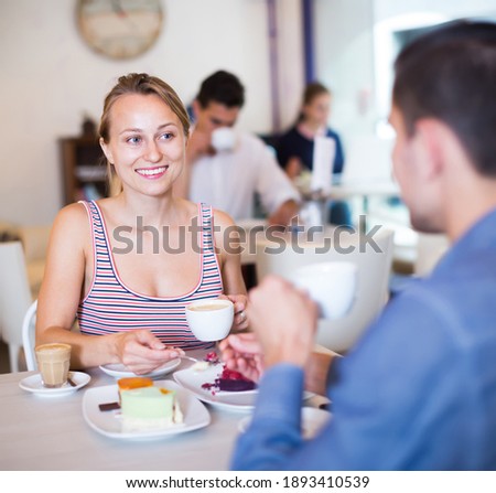 Ordinary smiling couple spending time together in cozy tearoom