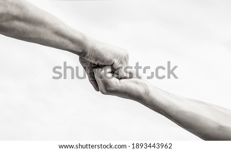Giving a helping hand. Hands of man and woman on sky background. Lending a helping hand. Hands of man and woman reaching to each other, support. Black and white. Royalty-Free Stock Photo #1893443962