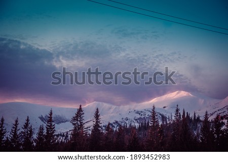 the first rays of the sun at dawn touch the snow-capped peaks of the mountains. High quality photo