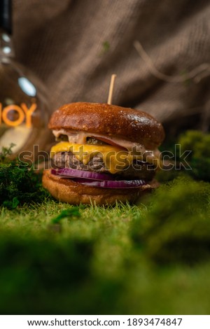 Homemade cheeseburger on the grass. Loft-style entourage.