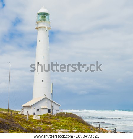 A beautiful shot of a lighthouse and the Atlantic ocean from the town of Cape in South Africa