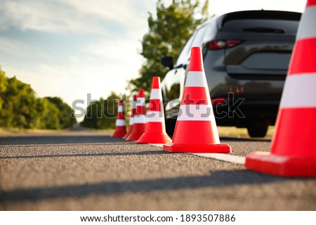 Traffic cones near car outdoors. Driving school exam Royalty-Free Stock Photo #1893507886