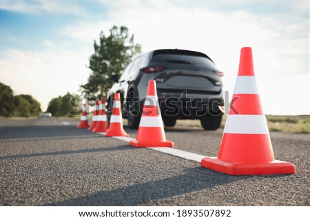 Traffic cones near car outdoors. Driving school exam Royalty-Free Stock Photo #1893507892