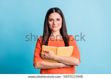 Portrait of attractive woman hold hug book eyewear look camera isolated on pastel blue color background