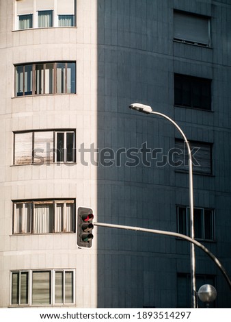 Photograph taken in Madrid of a gray building with a red traffic light