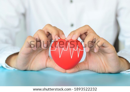 Good Healthcare and Insurance concept.Woman hand holding red heart with heart rate on blue background.Love and Family. Royalty-Free Stock Photo #1893522232