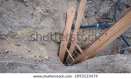 cable connections in the ground and ladder of wooden boards