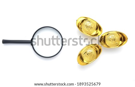 A picture of magnifying glass and golden ingot or "yuan bao" written in chinese for prosperity on isolated white background. Looking for prosperity concept