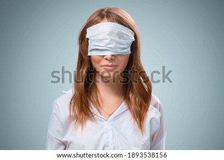 The protective mask on the girl is incorrectly put on. A masked nurse. Wrong. Quarantine during the virus. Self-isolation and illness. The doctor smiles. Coronavirus and protection.  Royalty-Free Stock Photo #1893538156
