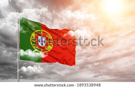 Portugal national flag cloth fabric on cloud background.