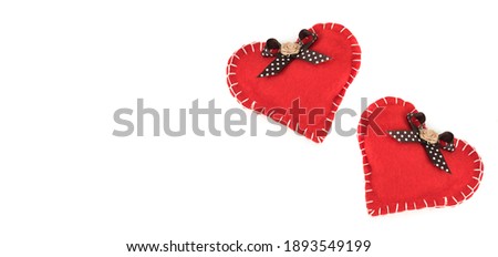 two Red felt heart with white stitches. A symbol of love handmade sewn with thread around the edge on a white background.
