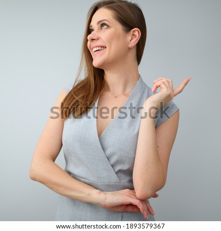Thinking business woman looking up. woman wearing gray dress isolated portrait.