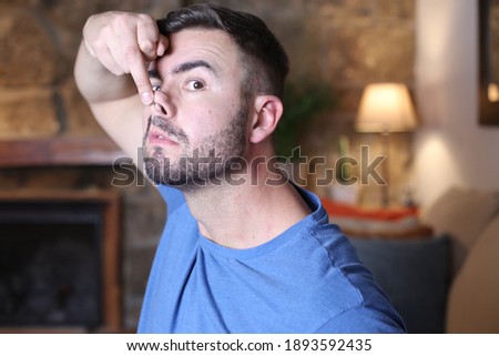 Man elevating nose with finger