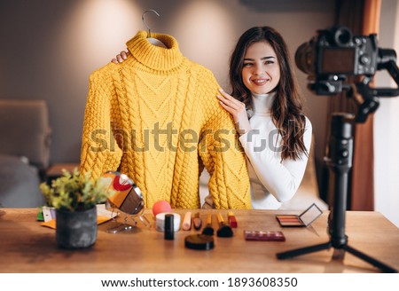 Beauty blogger sweet female filming daily make-up routine tutorial on camera. Influencer young woman live streaming cosmetics product review in home studio. Vlogger job. Showing clothes. Lookbook. Royalty-Free Stock Photo #1893608350