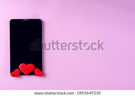 Black blank phone screen with red heart shape on pink background, copy space, minimalism, flat lay. Valentine day concept. Concept to like in social networks or Dating app