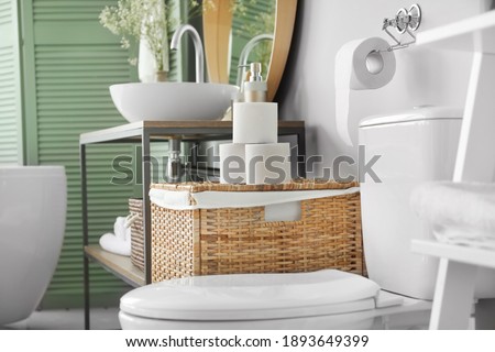 Toilet bowl and rolls of paper in restroom Royalty-Free Stock Photo #1893649399