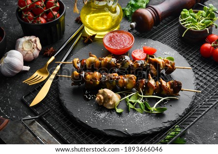 Rapana skewers with vegetables on a black stone plate. Restaurant food. Seafood. Rustic style. Flat Lay. Royalty-Free Stock Photo #1893666046