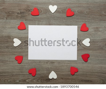 Valentine's day blank gift card with red hearts on wooden background.