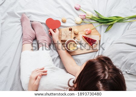 The girl in bed in the morning received flowers, gifts and breakfast in bed. Congratulations on Valentine's Day.