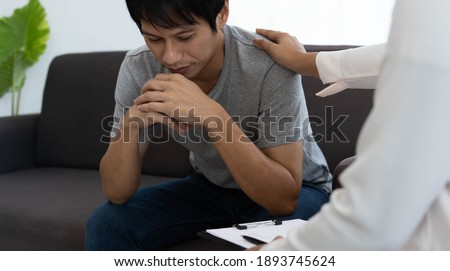 A doctor or psychiatrist provides counseling and encouragement to asian male patients receiving treatment for psychological symptoms. Royalty-Free Stock Photo #1893745624