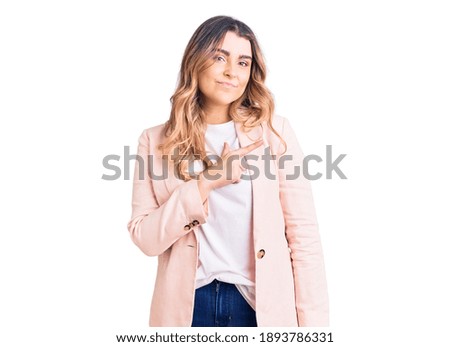 Young caucasian woman wearing business clothes cheerful with a smile on face pointing with hand and finger up to the side with happy and natural expression 