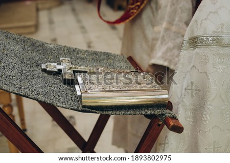 The Bible. The book of prayers and the cross lie on a special table in front of the holy father. A religious-themed image.