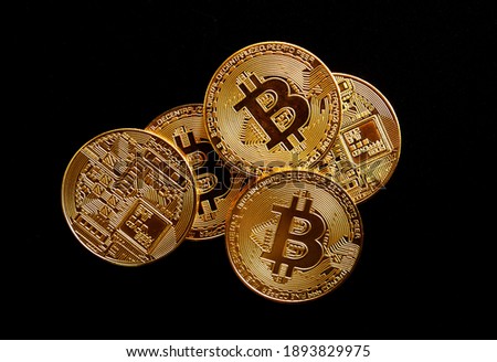 Close up of gold bitcoin on black background with selective focus