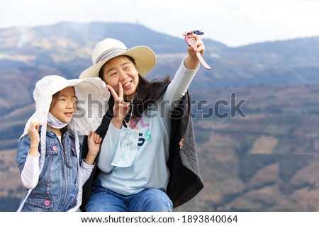 2 sisters wearing hats are selfie with the mountain in background