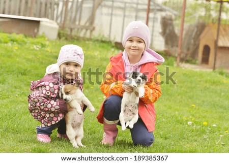 Two sisters playing with puppies 