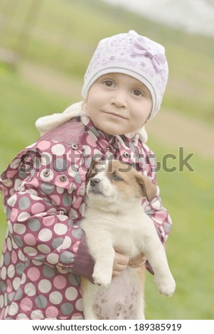 Cute little girl hugging dog puppy 