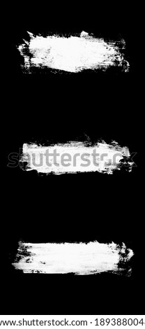set three white strokes of paint isolated on a black background. design brush