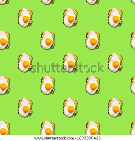 Seamless pattern of sandwich with fried eggs on green background