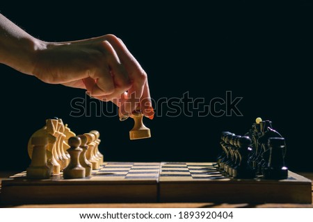 Woman playing chess and hold pawn on black background. Mockup. Blank space for text