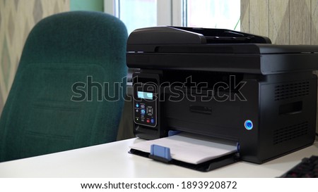 The printer on the table typed a word hello on a piece of paper. Office space, table, chair and printer 4k