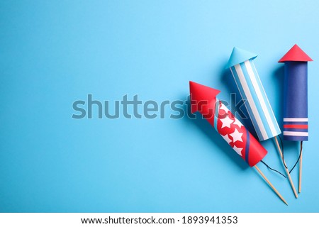 Firework rockets on light blue background, flat lay. Space for text Royalty-Free Stock Photo #1893941353