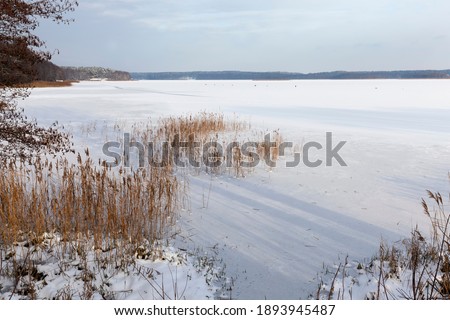 snow drifts on the lake, snow drifts on the ice of the lake after the last snowfall, frozen lake in winter cold weather after the snow fell