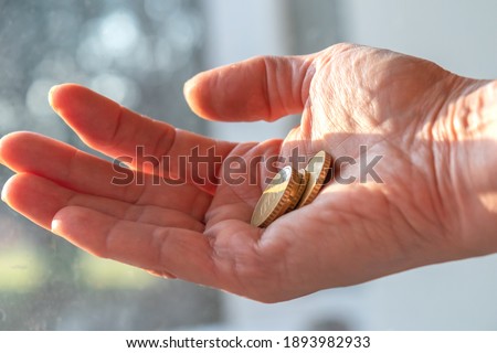 female hand close-up, palm with coins