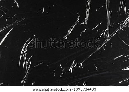 Transparent plastic wrap on the black background. Clean blank texture overlay effect template. Isolated wrinkle surface branding mock-up. Royalty-Free Stock Photo #1893984433
