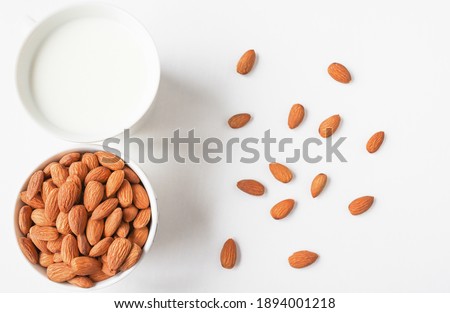 Almond milk and almonds on a light wooden background. Diet drink.