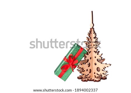 Gift next to a wooden Christmas tree on a white background. Isolate
