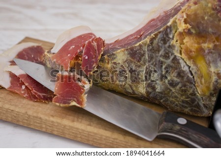 Serrano ham leg shoulder on its wooden base ready to be cut