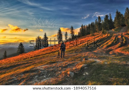 Woman on a hiking trip in the mountains walking on rocks. colorful autumn sunrise